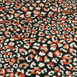 Tissu Viscose motif léopard orange et écru fond Noir