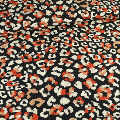 Tissu Viscose motif léopard orange et écru fond Noir