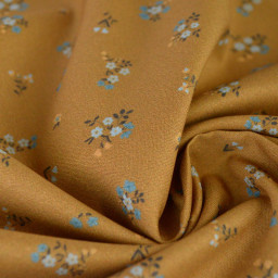 Popeline de coton Bisou motif fleurs bleues fond Ocre