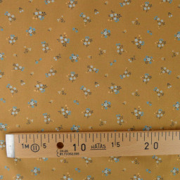 Popeline de coton Bisou motif fleurs bleues fond Ocre